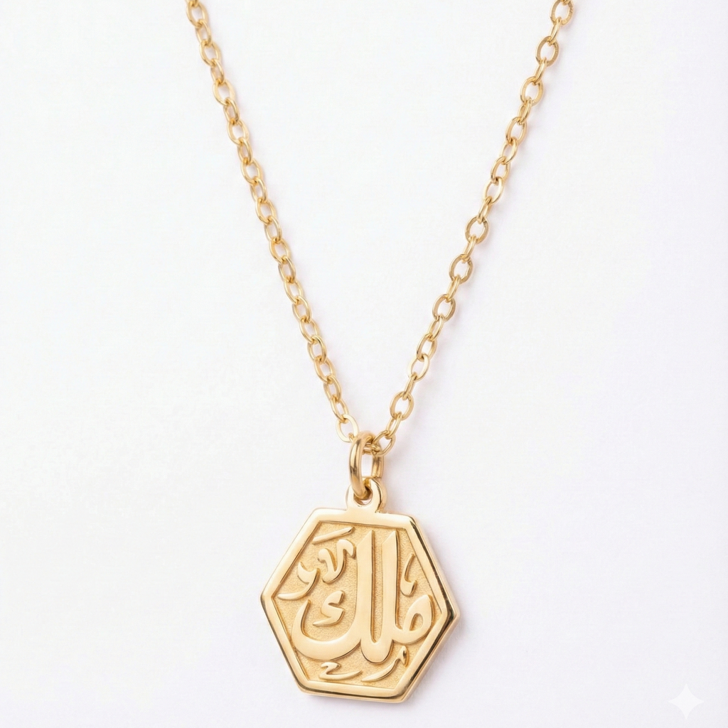 Gold necklace with a hexagonal pendant on a white background