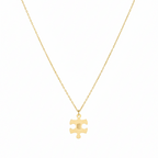 Gold necklace with a puzzle piece pendant on a white background