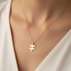 Gold necklace with a puzzle piece pendant on a neutral background